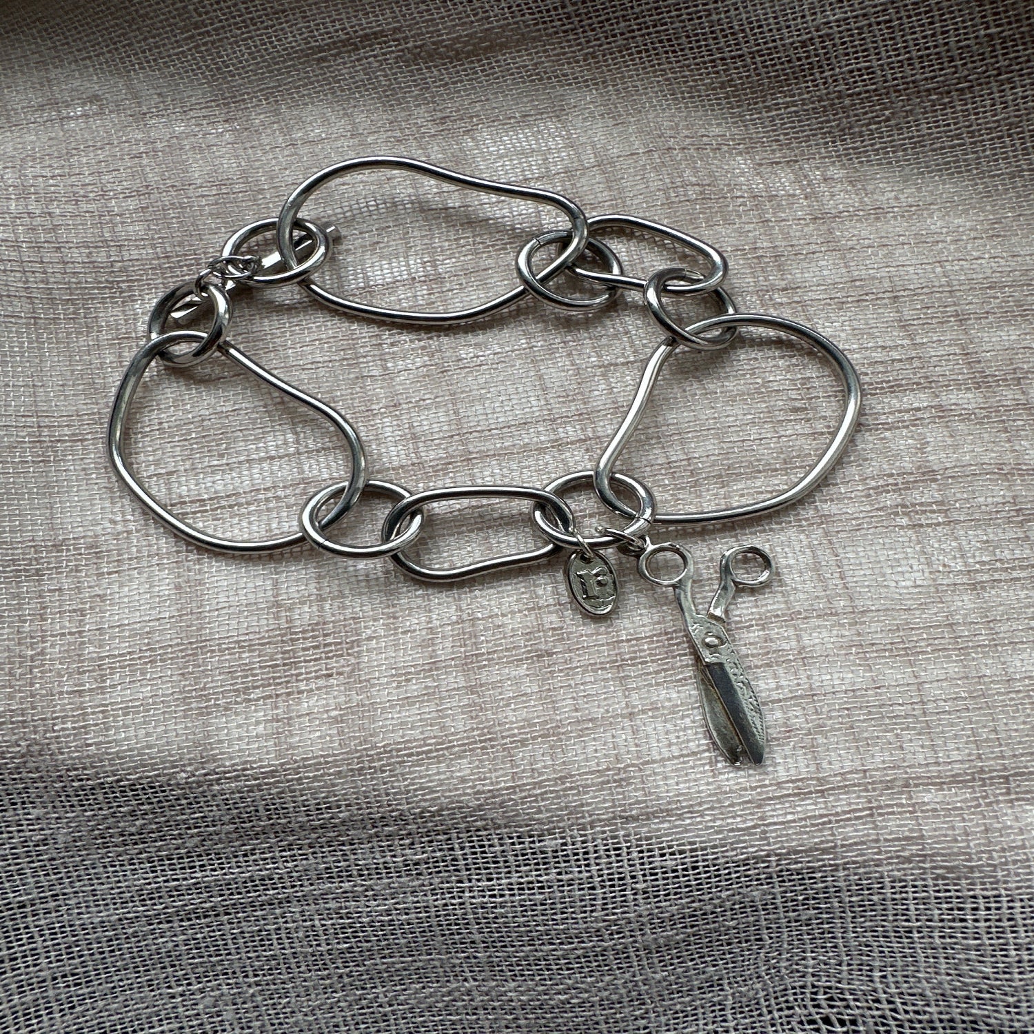 Statement charm bracelet by Regilt â€“ bold cut-style vintage piece.